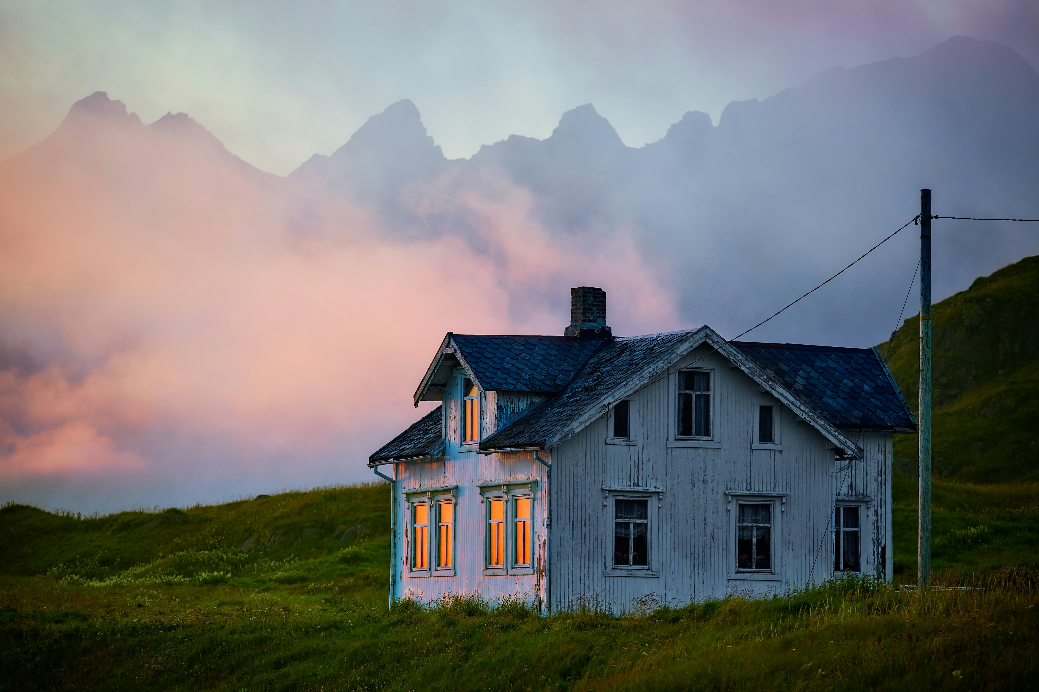 white and black house on green grass field under cloudy sky during daytime